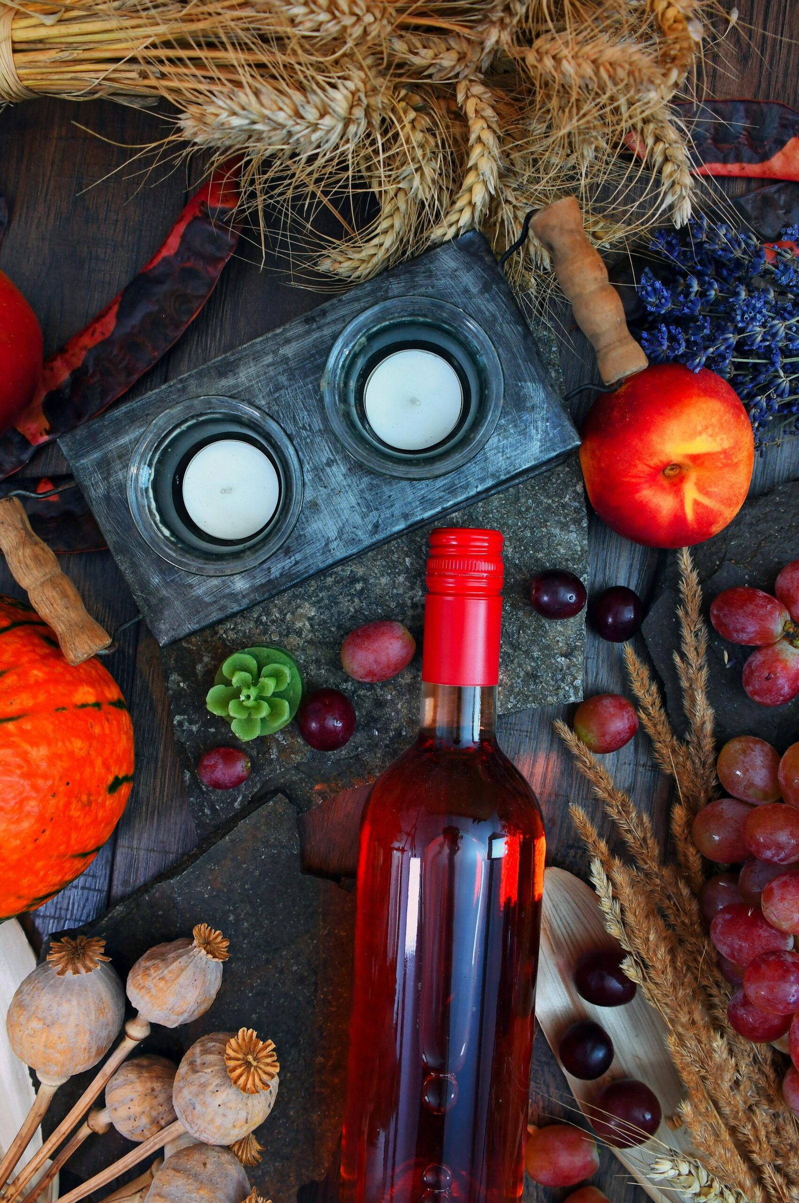 Vibrant autumn still life featuring wine bottle, fruits, and seasonal harvest decor.